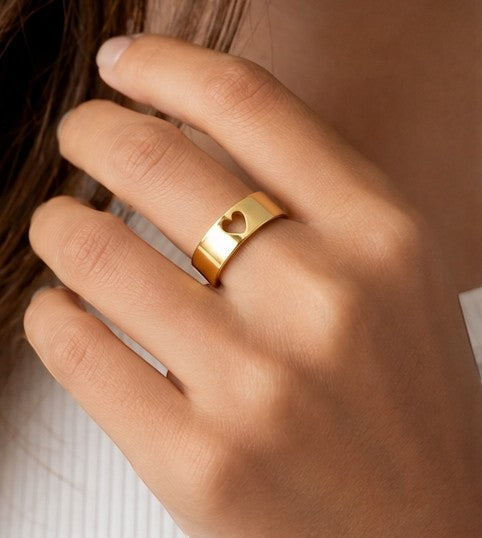 JOYAS gold band ring featuring a delicate cut-out heart design worn on a finger